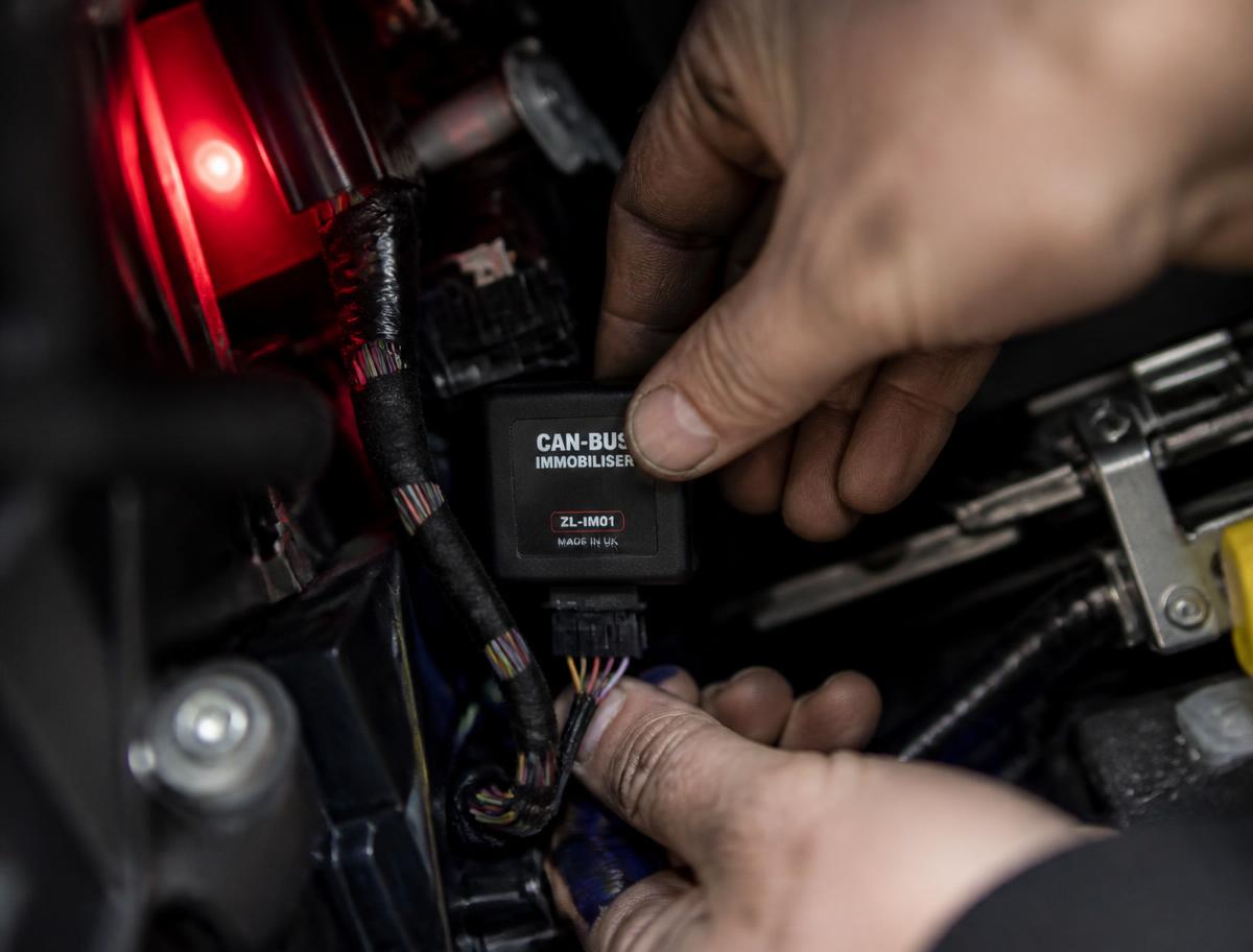 A CAN-bus immobiliser being fitted behind a car's dashboard